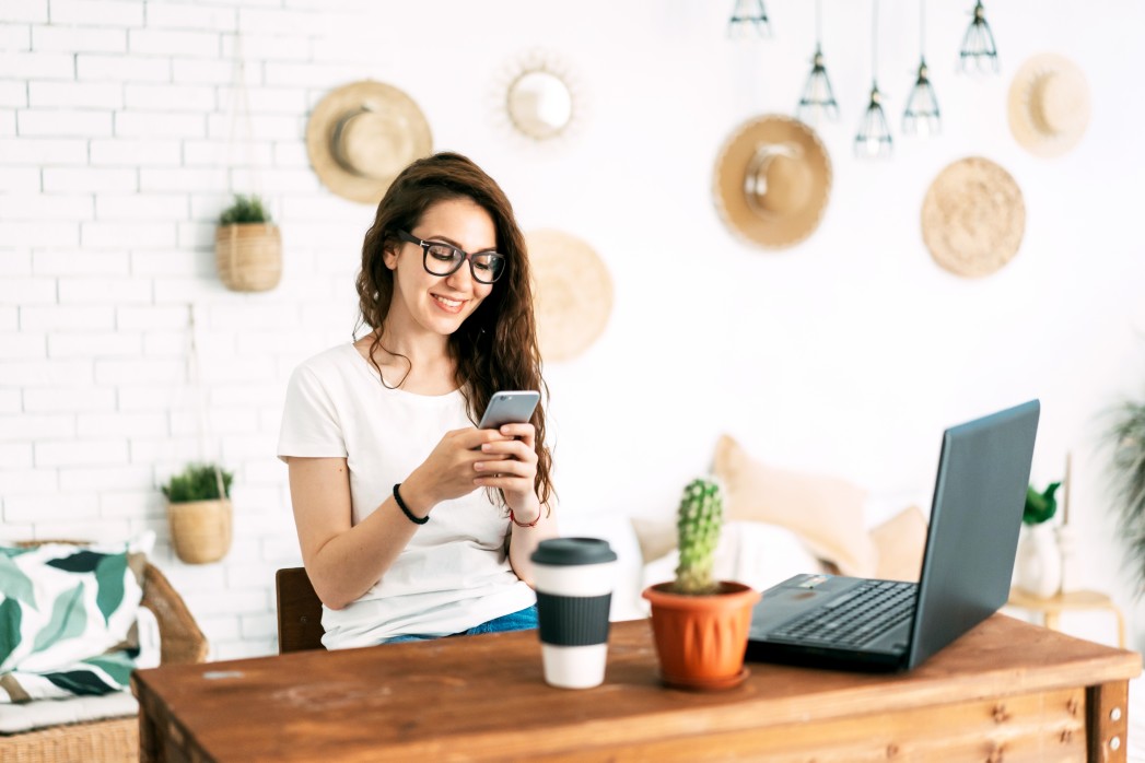 young-positive-business-woman-at-her-desk-uses-the-phone-for-social-networks_t20_P02347